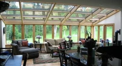 Sunroom with expansive glass walls and ceiling, offering a scenic view and abundant sunlight. Perfec.