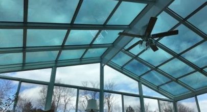 Sunroom with glass roof and ceiling fan for natural light and comfort.