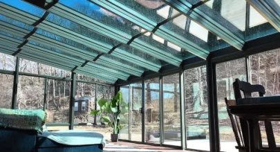 Sunroom with glass ceiling and expansive windows for natural light.