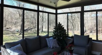 Bright sunroom with expansive glass windows and comfortable furniture, perfect for relaxing and enjo.
