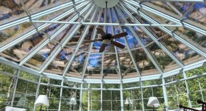Sunroom with glass dome ceiling and ceiling fan for natural light and outdoor views.